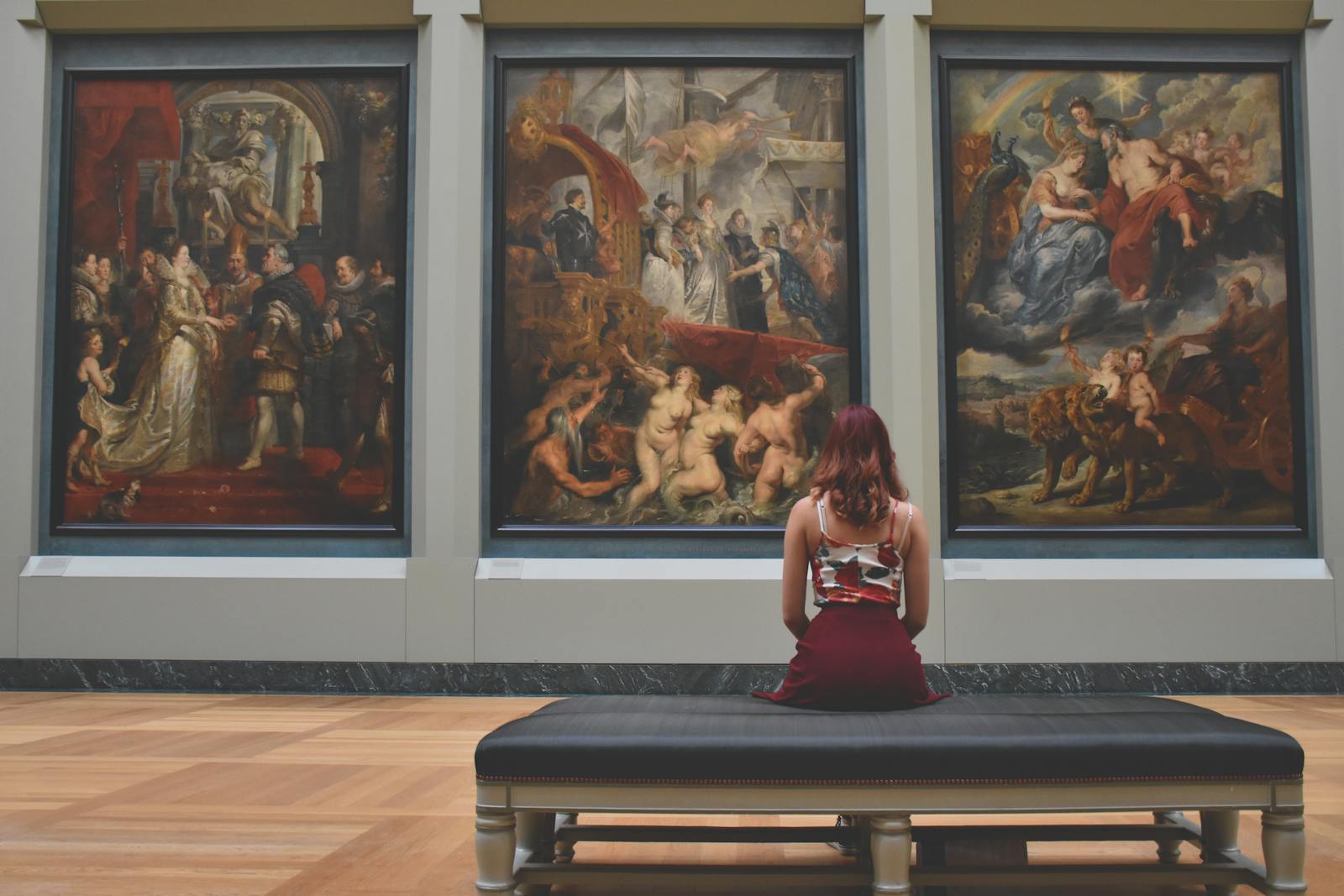 Woman viewing classical paintings in an art museum gallery - hidden details in famous artworks